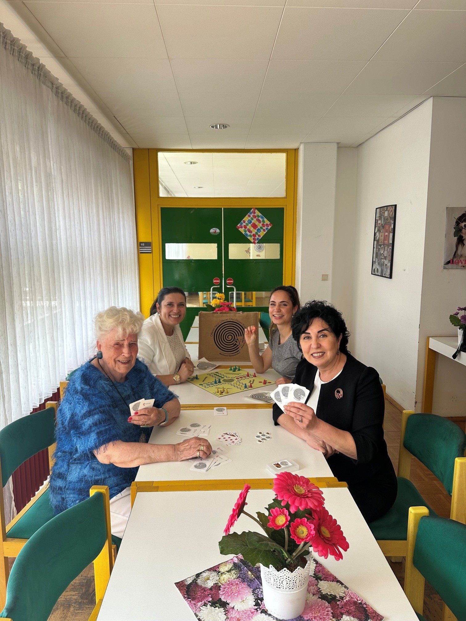 Miteinander Spaß finden: ehrenamtliche Club-Vorständin Gisela Peil, Einsamkeitsbeauftragte Katharina Schulz, Clubleiterin Jenifer Rodriguez Andres und Bezirksbürgermeisterin Emine Demirbüken-Wegner (v.l.) beim geselligen Kartenspiel